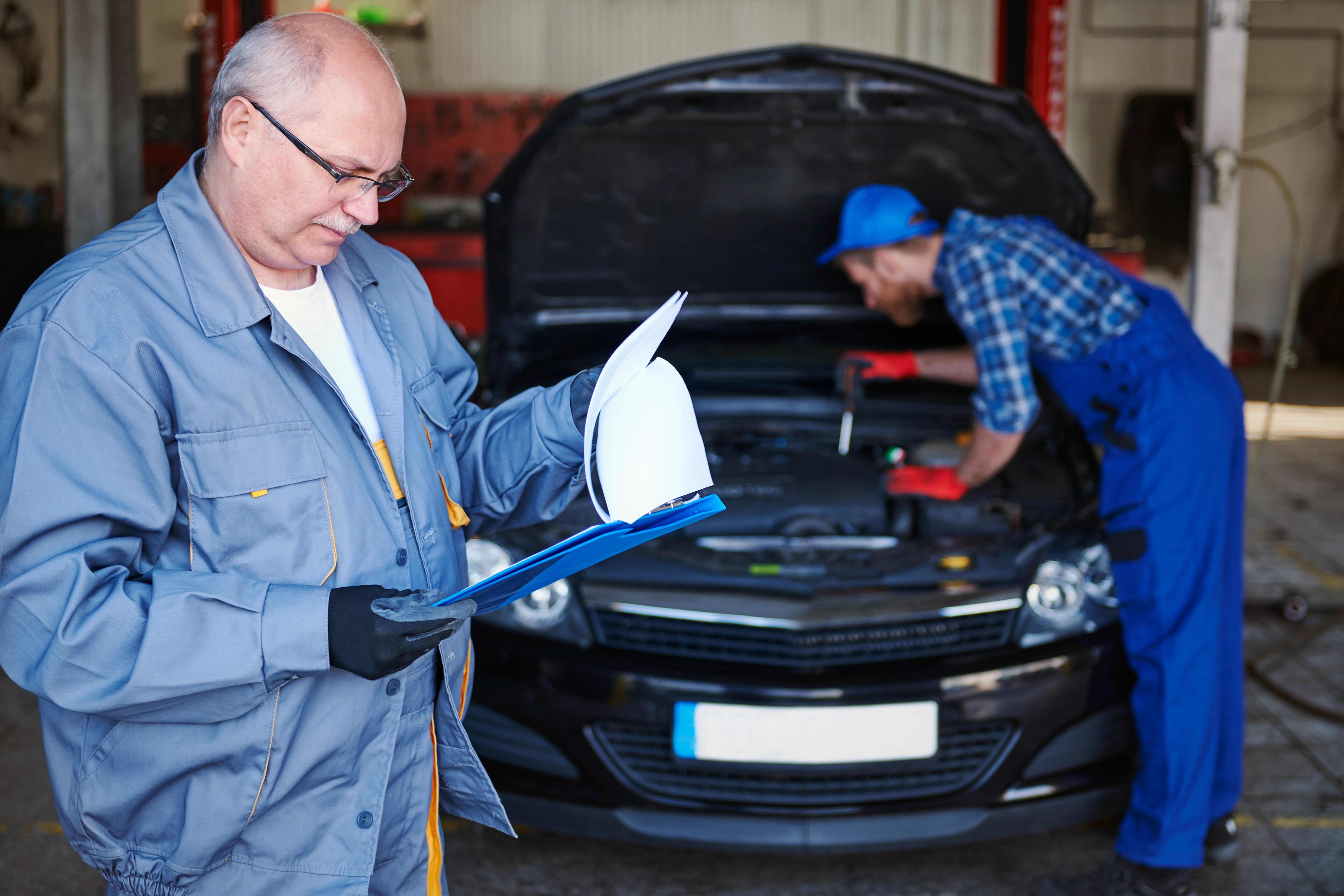 Auto repair mechanics working on vehicles