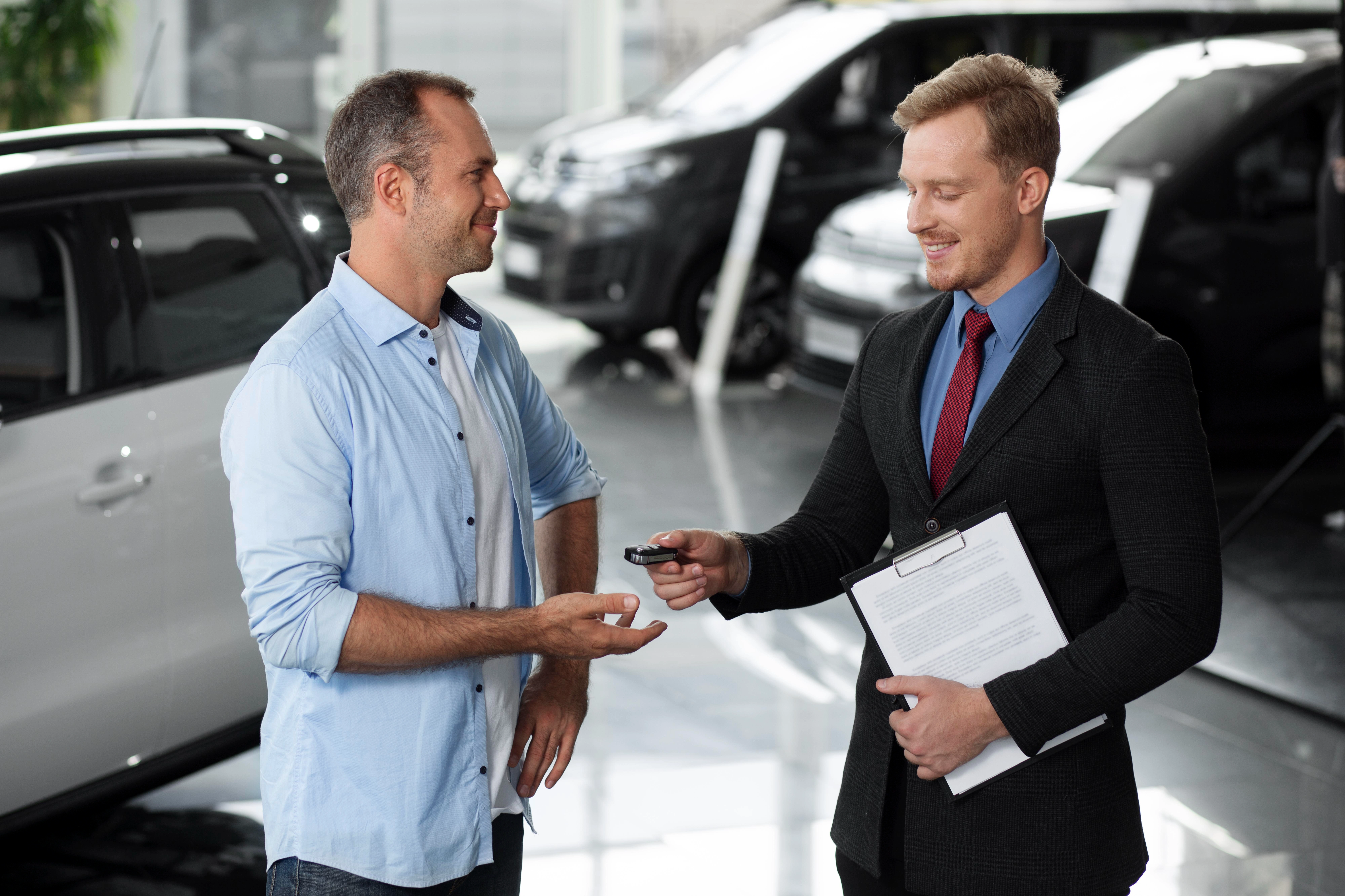 Car dealer showing vehicles to customers